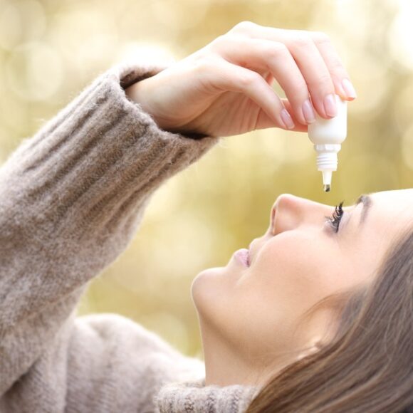 Woman applying eye drops